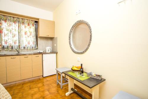 a kitchen with a table and a mirror on the wall at Takis Hotel Apartments in Ialysos