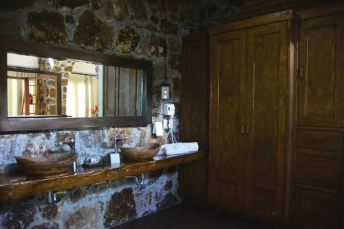 a stone bathroom with two sinks and a mirror at Casa Legado in Aguascalientes