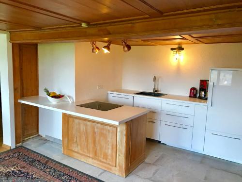eine Küche mit weißen Schränken und einer Arbeitsplatte in der Unterkunft Echtes Schwarzwaldhaus - Traditionell & Modern in Bernau im Schwarzwald