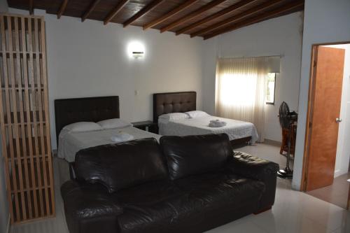 a living room with two beds and a leather couch at Black Sheep Medellin in Medellín