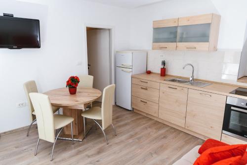 Hrvatini的住宿－Apartma Nika，带桌椅的厨房和带水槽的厨房