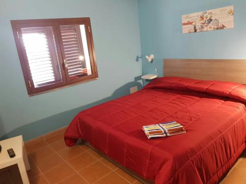 a bedroom with a red bed and a blue wall at Bed and fly Aeroporto Fontanarossa in Catania