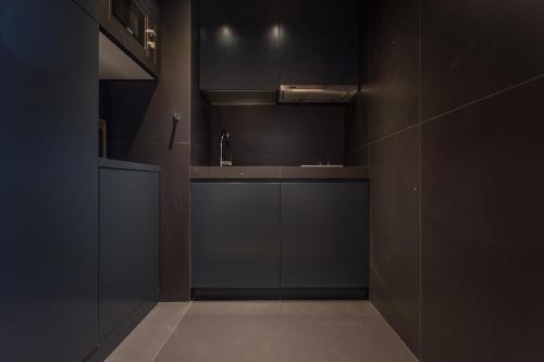 a kitchen with black cabinets and a sink at Quinta dos Peixes Falantes in Ribeira Grande