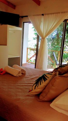 a bedroom with a large bed with a window at Cabañas Te Maori in Hanga Roa