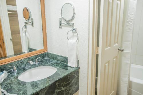 a bathroom with a sink and a mirror at Capital Plaza in Chetumal