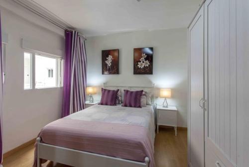 a bedroom with a large bed with purple pillows at Espectacular piso Cullera in Cullera