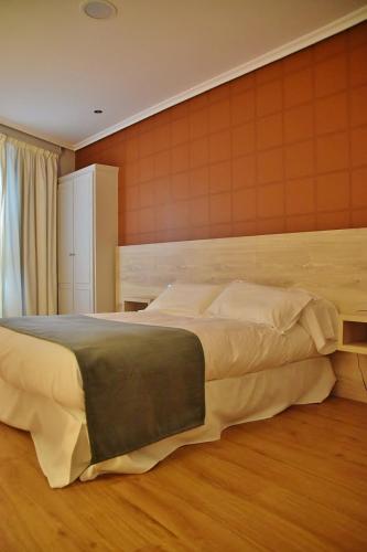 a bedroom with a large bed in a room at Hospedium Hotel La Marina Costa da Morte in Cee
