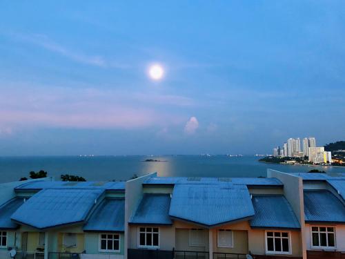 a view of a building with blue roofs and the moon at Shamrock Boutique Villa - Stay for 12 person in Batu Ferringhi