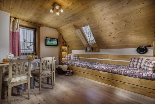 a room with a bed and a table and chairs at Chata Škerda - Zuberec in Zuberec
