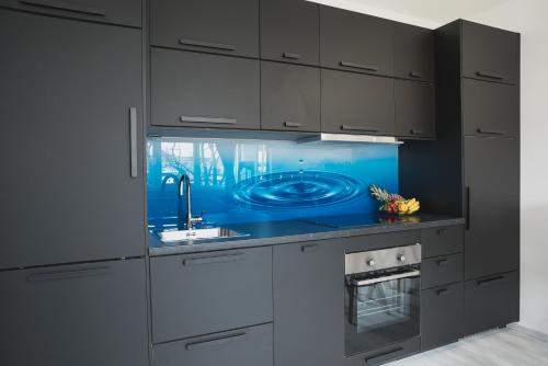 kuchnia z białymi szafkami i niebieskim blatem w obiekcie Drop (in) Apartment w Zagrzebiu