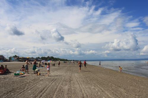 un gruppo di persone che camminano sulla spiaggia di Saga Resort a Wasaga Beach