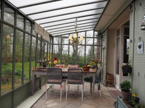 a screened in porch with a table and chairs at Cour Tholmer in Touques
