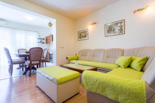 ein Wohnzimmer mit einem Sofa und einem Tisch in der Unterkunft Apartments Ave in Podstrana