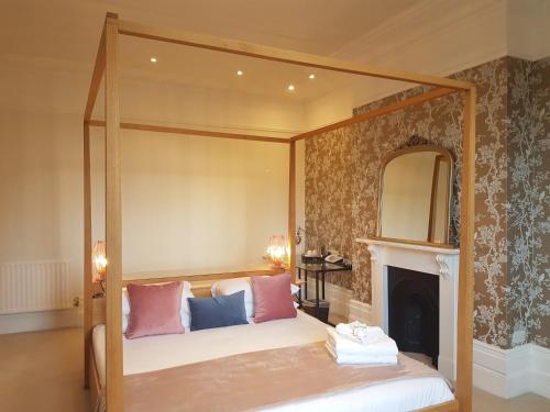 a bedroom with a canopy bed with a fireplace at The Relish in Folkestone