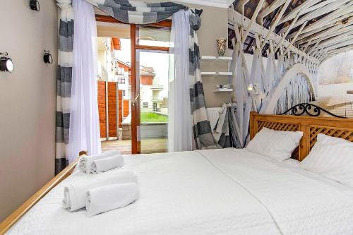 グダニスクにあるFour - Neptun Park by OneApartmentsのベッドルーム1室(白いベッド1台、タオル2枚付)
