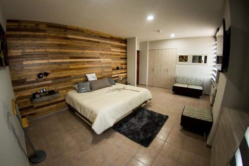 萊昂的住宿－Hotel Real Azteca Boulevard，一间卧室设有一张床和木墙