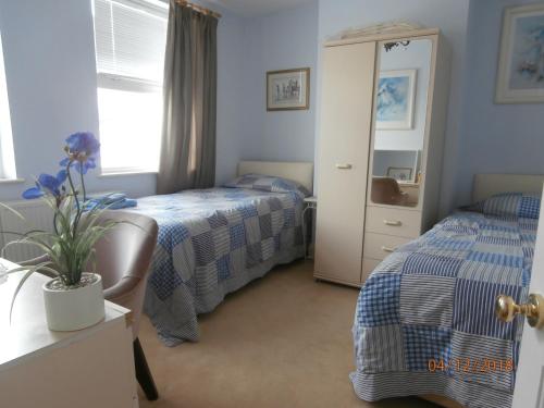 a bedroom with two beds and a mirror at Riverside House in Bideford