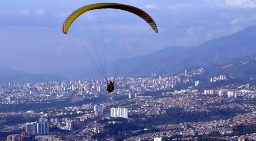 a person in a parachute flying over a city at Hotel Bucarica Plaza in Bucaramanga