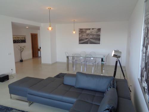 a living room with a blue couch and a table at Paradisus Stylish Family Living in a 3-Bedroom Condo with Pool in Caniço