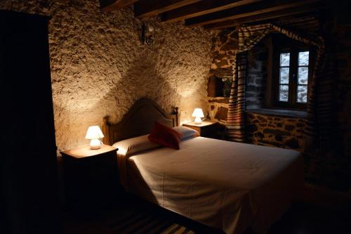 1 dormitorio con 1 cama con 2 lámparas en Casa Rural Xiromo, en San Ciprián