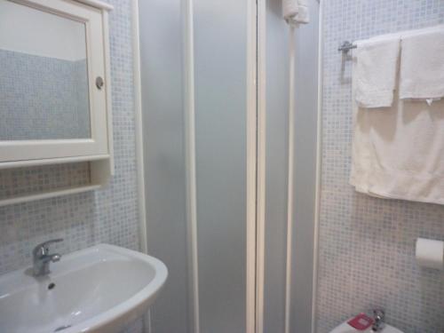 ein weißes Badezimmer mit einem Waschbecken und einem Spiegel in der Unterkunft B&B Dimora di Traiano in Terracina