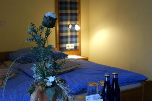 a room with a bed with bottles of wine and flowers at Wolffhotel in Kopp