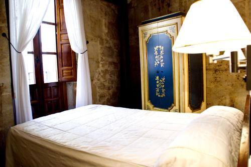 a bedroom with a bed with a blue door and a lamp at Hotel Microtel Placentinos in Salamanca