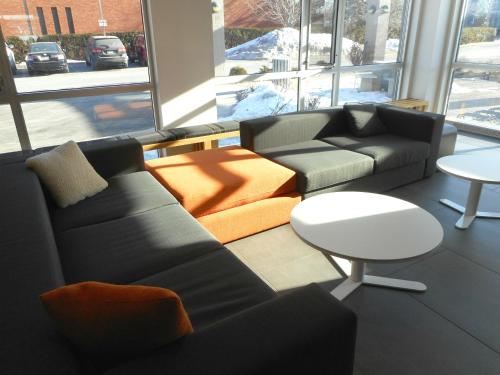 a living room with a couch and a table at Le Dauphin Montréal-Longueuil in Longueuil