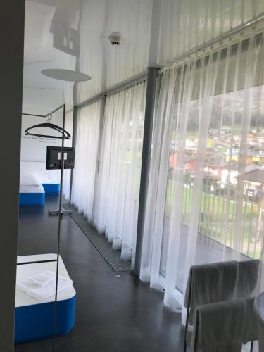 a room with large windows with white curtains at Chromotel self check-in in Mezzovico