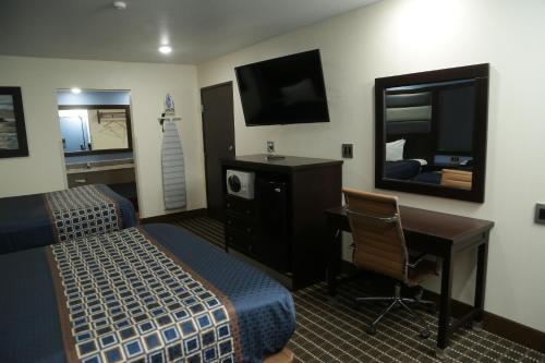 a hotel room with a bed and a desk and a mirror at Theroff's Motel in Washington