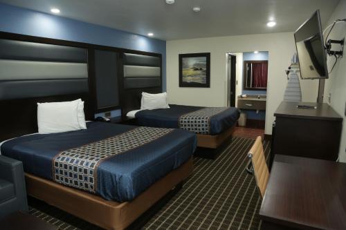 Habitación de hotel con 2 camas y TV de pantalla plana. en Theroff's Motel, en Washington