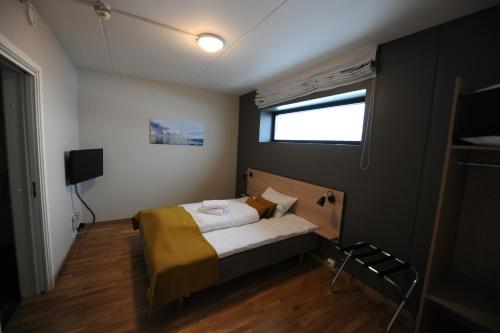 a small bedroom with a bed and a window at Tananger Apartment Hotel in Tananger