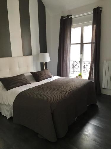 une chambre avec un grand lit et une fenêtre dans l'établissement Victoria's House, à Lille