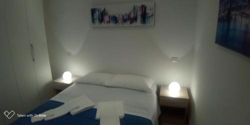 a bedroom with a bed and two lights on two tables at InBlu in Bari