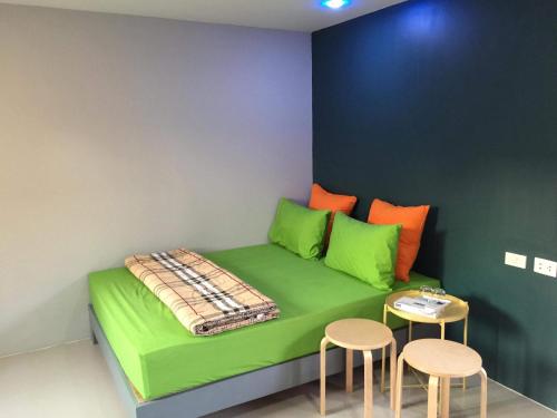a green bed with two chairs and a table at Nature Home in Phra Nakhon Si Ayutthaya