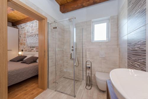 La salle de bains est pourvue d'une douche, d'un lit et d'une baignoire. dans l'établissement Villa Đelozija, à Sukošan