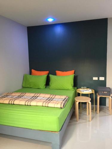 a green bed in a room with a table at Nature Home in Phra Nakhon Si Ayutthaya