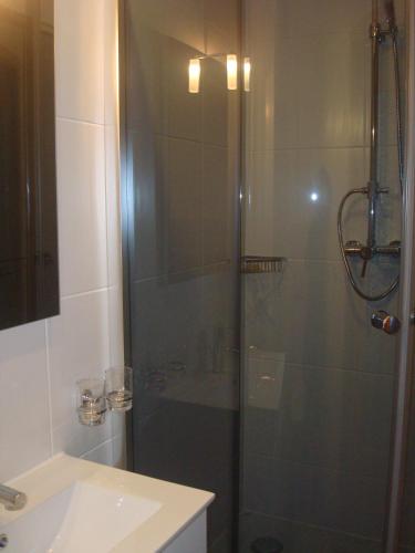 a shower with a glass door next to a sink at Gästehaus Sol Tour in Ahrensfelde