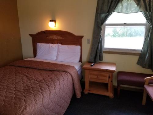 a small bedroom with a bed and a window at Rodeway Inn La Crosse in La Crosse