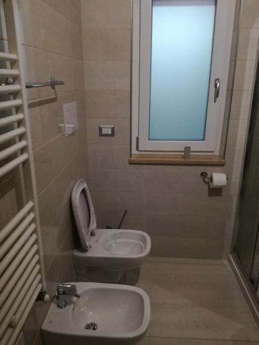 a bathroom with a sink and a toilet and a window at Hotel Tulbia in Tolve