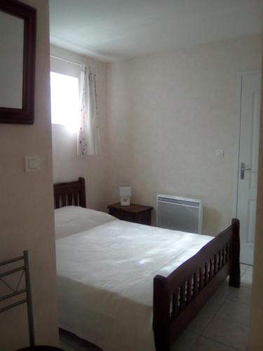 une chambre avec un grand lit et une fenêtre dans l'établissement La belle étape, à Sérignan