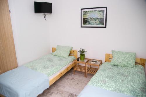 a room with two beds and a small table at Na Krzywej in Chęciny