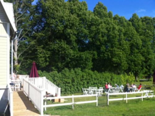 a group of people sitting at tables in a yard at Ardrebo B&B in Ljugarn