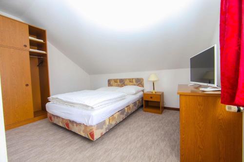 a small bedroom with a bed and a television at Hard Rock Rooms for two in Livno