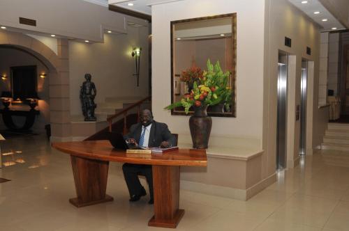 a man sitting at a table with a laptop at Apollo Hotel in Johannesburg