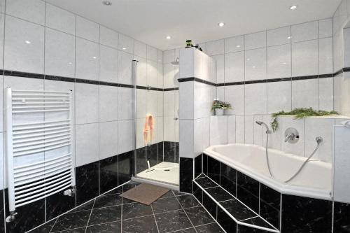 a bathroom with a tub and a shower and a toilet at Pension A1 Stuckenborstel in Sottrum