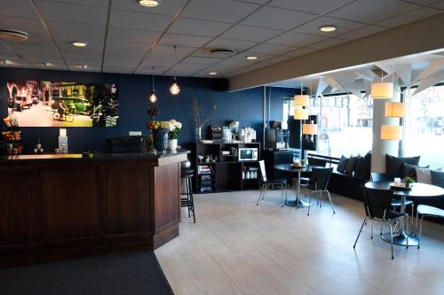 a restaurant with a bar and tables and chairs at Best Western Malmia Hotel in Skellefteå