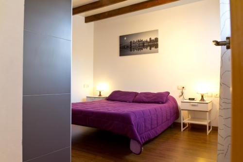 ein Schlafzimmer mit einem lila Bett in einem Zimmer in der Unterkunft My Penthouse Valencia in Valencia