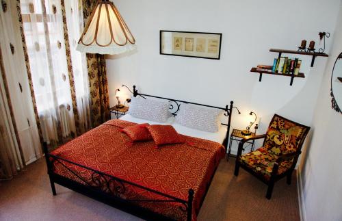 a bedroom with a red bed and a chair at Traben Apartments "TenVIK" in Traben-Trarbach