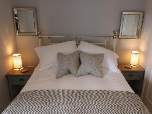 a bedroom with a bed with two pillows and two lamps at Inglenook Guest House in Ingleton 